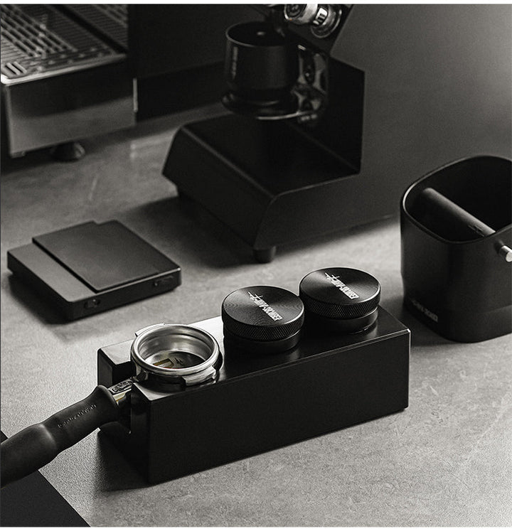 MHW-3BOMBER CD-Texture Leveling Tool 58.35 mm distributor in black (Black) on a tamping station next to the portafilter