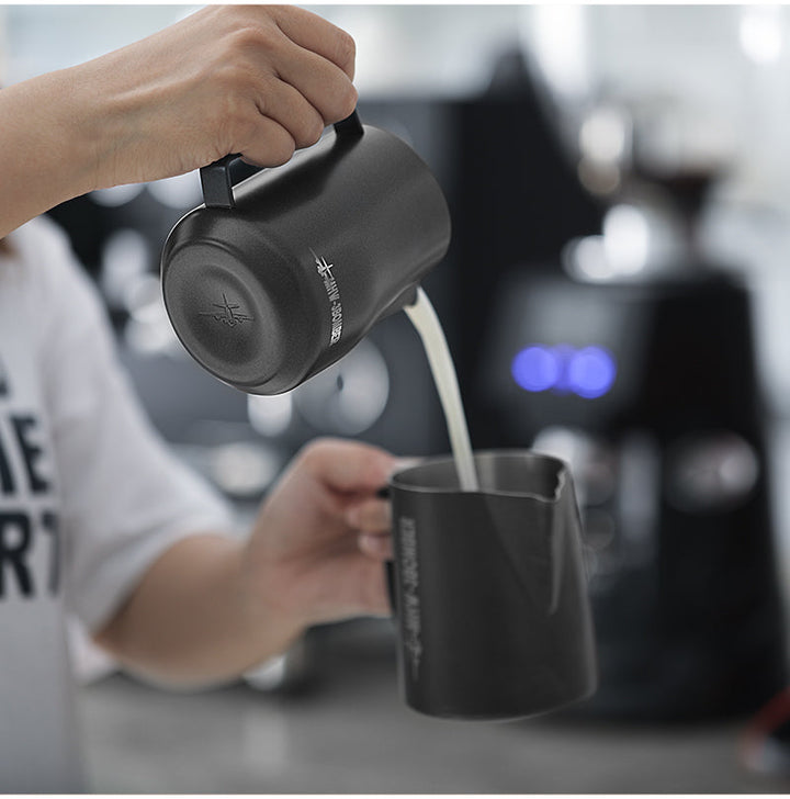 Pichet à lait MHW-3BOMBER Turbo en noir mat (Matte Black) avec un filet de lait pendant le versement