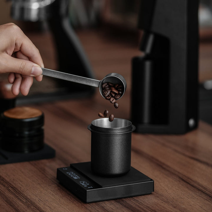 Gobelet de dosage MHW-3BOMBER 150 ml 58 mm en noir (Black) avec grains de café sur la balance