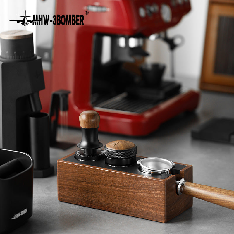 MHW-3BOMBER multifunctional portafilter holder tamping station in walnut with black (Walnut/Black) with portafilter, tamper and distributor in front of the espresso machine
