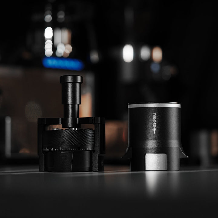 Distributeur à aiguilles MHW-3BOMBER SE Pro 58 mm en noir (Black) avec fixation magnétique, posé sur le bar à café