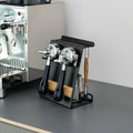 Flate Barista Stand Mini em preto junto a uma máquina com porta-filtro, com dois porta-filtros, jarro de leite e escova de limpeza