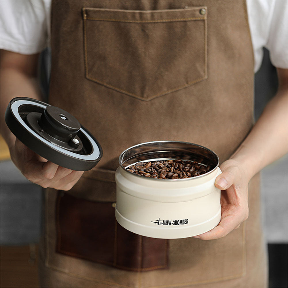 Boîte sous vide MHW-3BOMBER 750 ml en blanc avec couvercle ouvert et grains de café
