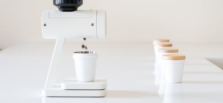 Acaia Orion Nano in Weiss dosiert Bohnen in einen Becher – Coffee Coaching Club 14