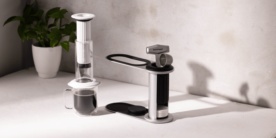 AeroPress Premium Weiss auf einer Glastasse neben einem Ständer auf der Kaffeebar – Coffee Coaching Club 13