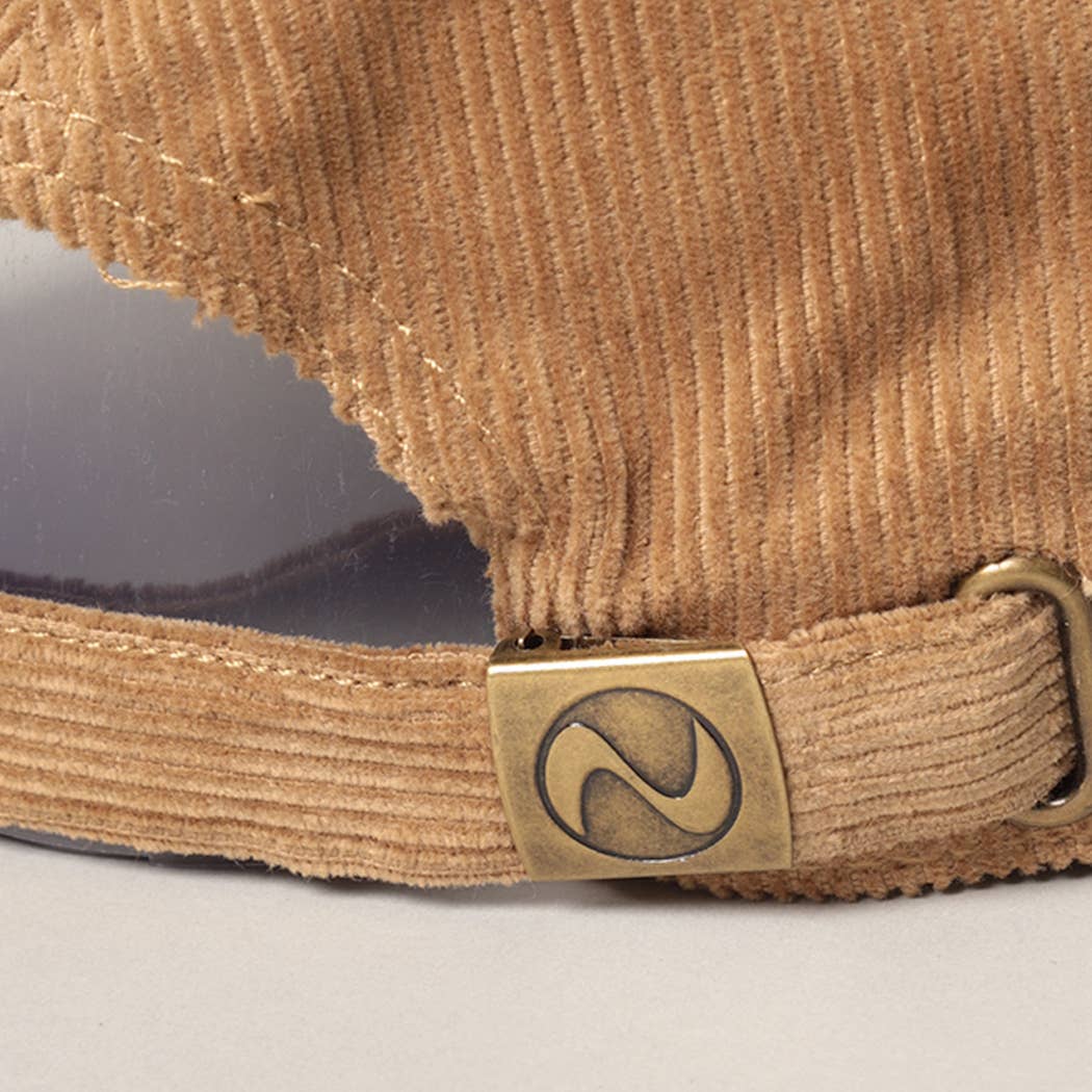 Primer plano de la hebilla metálica ajustable del cierre en una gorra de pana tan