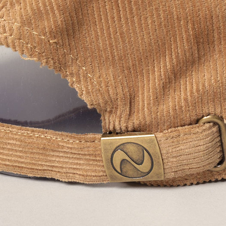 Primer plano de la hebilla metálica ajustable del cierre en una gorra de pana tan