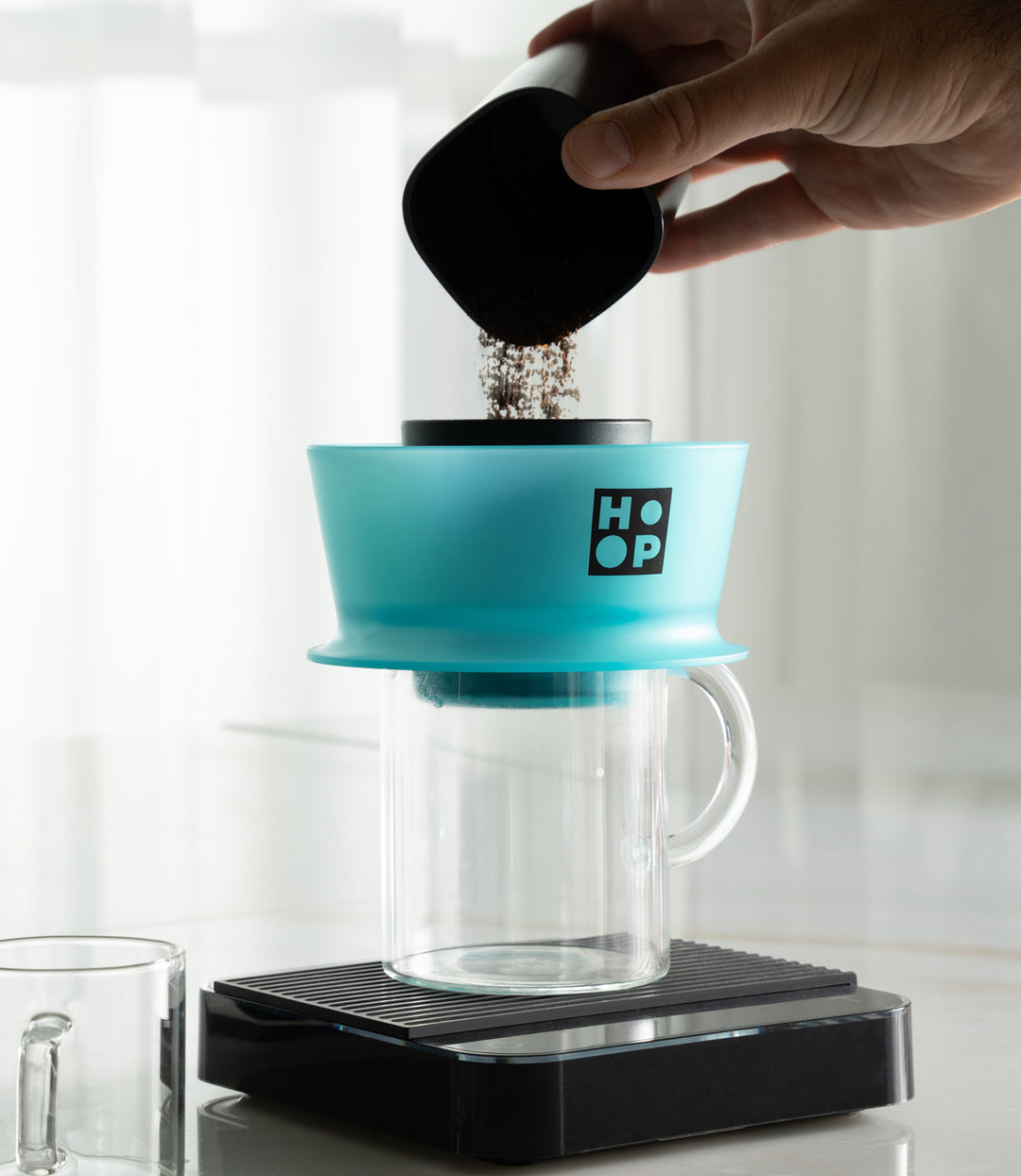 Ceado Hoop Coffee Brewer Turquoise on a glass carafe and scale, ground coffee being added – Coffee Coaching Club 13