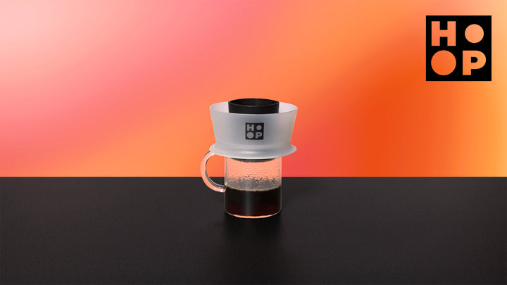Ceado Hoop Coffee Brewer light on a glass carafe with filter coffee against an orange background – Coffee Coaching Club 18