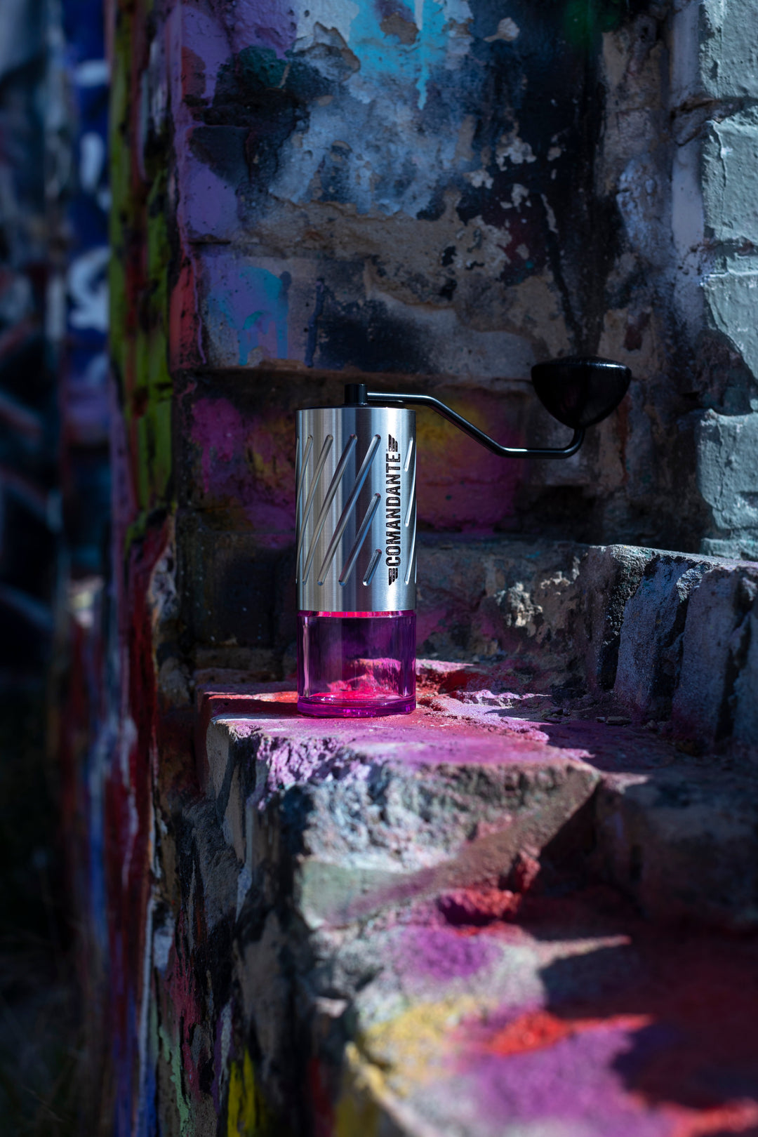 Comandante C60 Baracuda Stone Washed auf einer Steinmauer mit Graffiti – Coffee Coaching Club 10