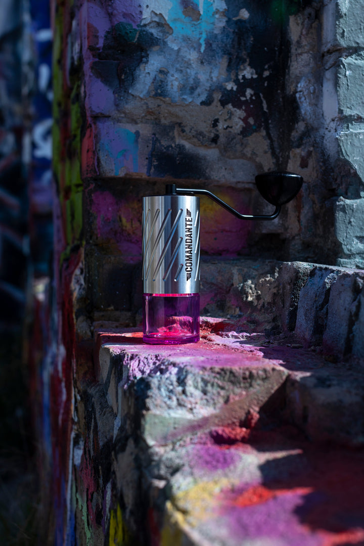 Comandante C60 Baracuda Stone Washed auf einer Steinmauer mit Graffiti – Coffee Coaching Club 10