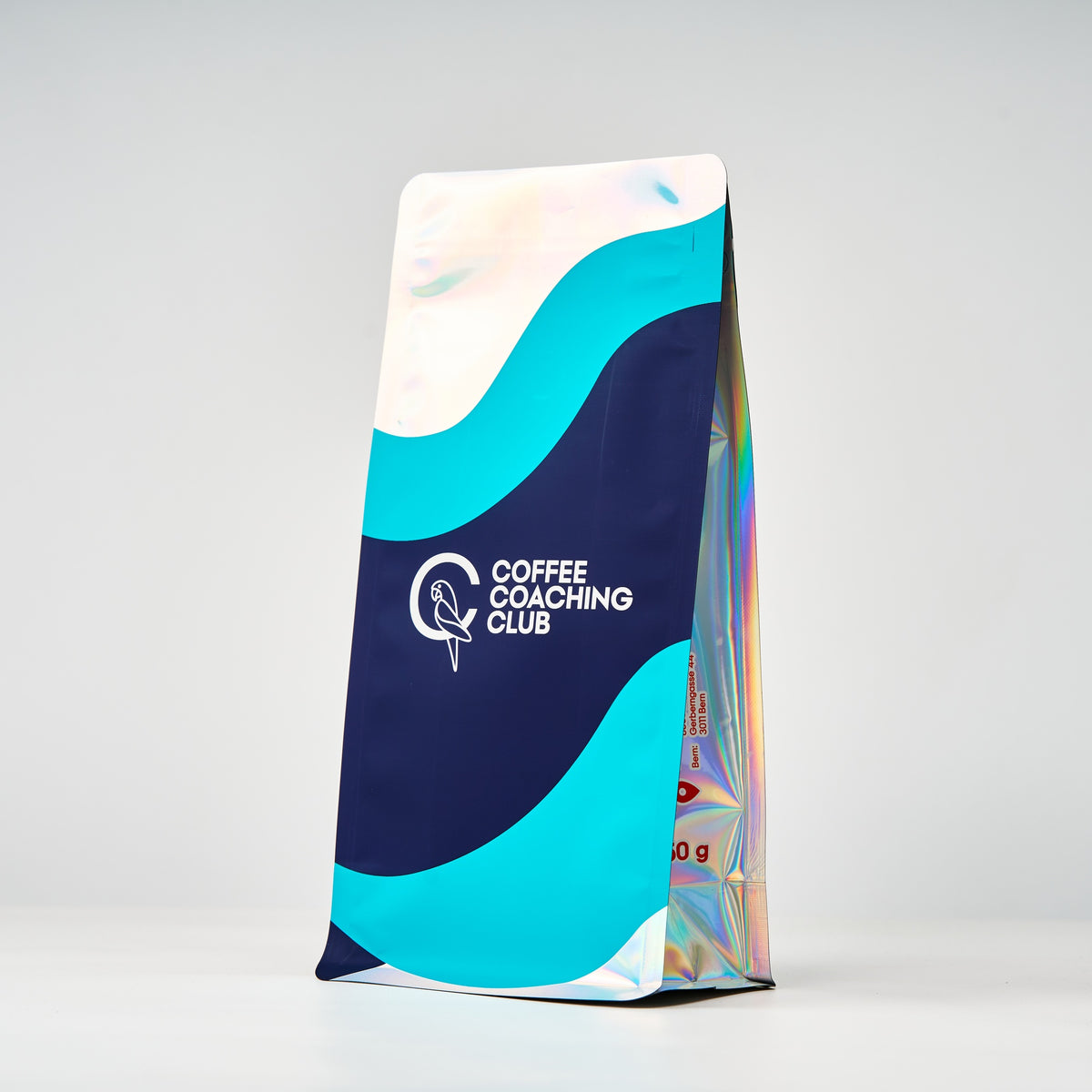Café en grains Cozy Chocolate – sachet de 250 g vu de côté avec soufflet holographique, design bleu marine et turquoise – Coffee Coaching Club