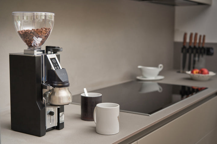 Eureka Mignon Libra 65 All Purpose Schwarz mit Becher in der Gabel in der Küche – Coffee Coaching Club 23