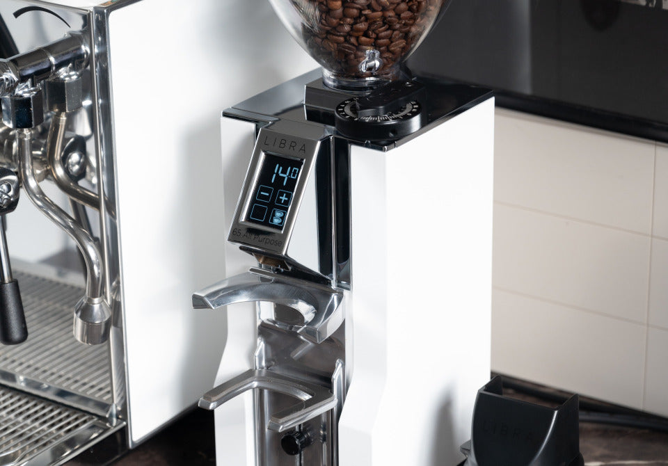 Eureka Mignon Libra 65 All Purpose Weiss neben Espressomaschine – Coffee Coaching Club 30