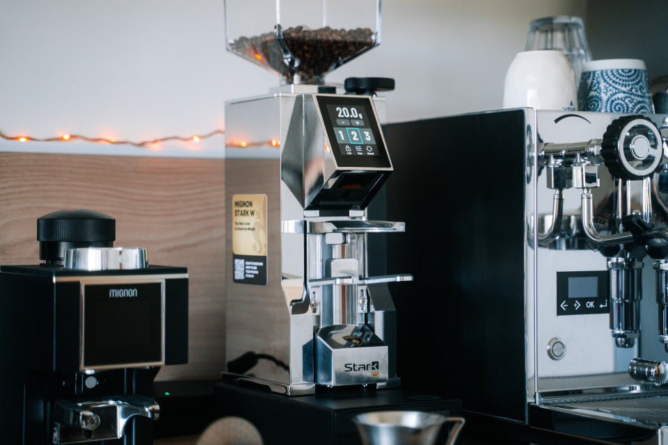 Eureka Mignon Stark W Chrom auf der Theke mit Espressomaschine – Coffee Coaching Club 26