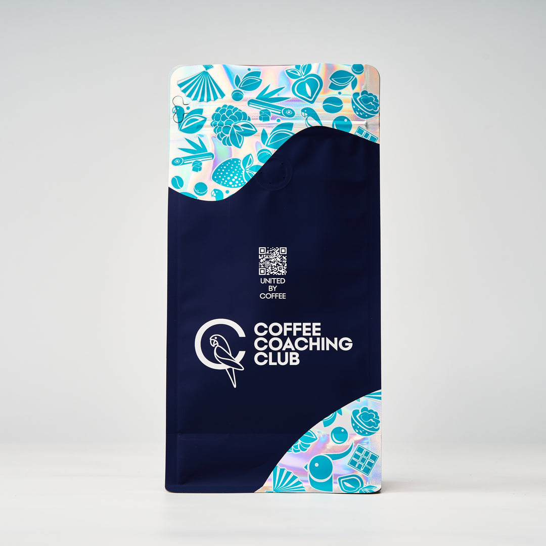 Caffè in grani Jungle Flower – retro del sacchetto da 250 g con codice QR «United by Coffee», design blu navy e turchese – Coffee Coaching Club