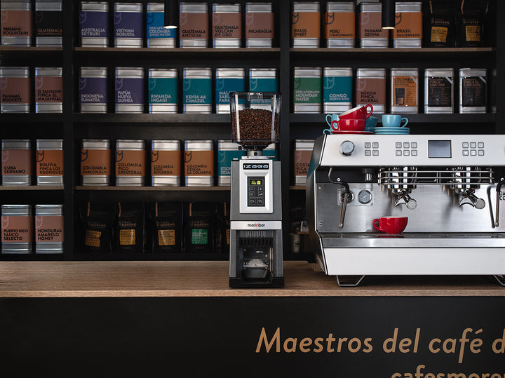 Markibar IZAGA KEY im Café vor einem Regal mit Kaffee – Coffee Coaching Club 10