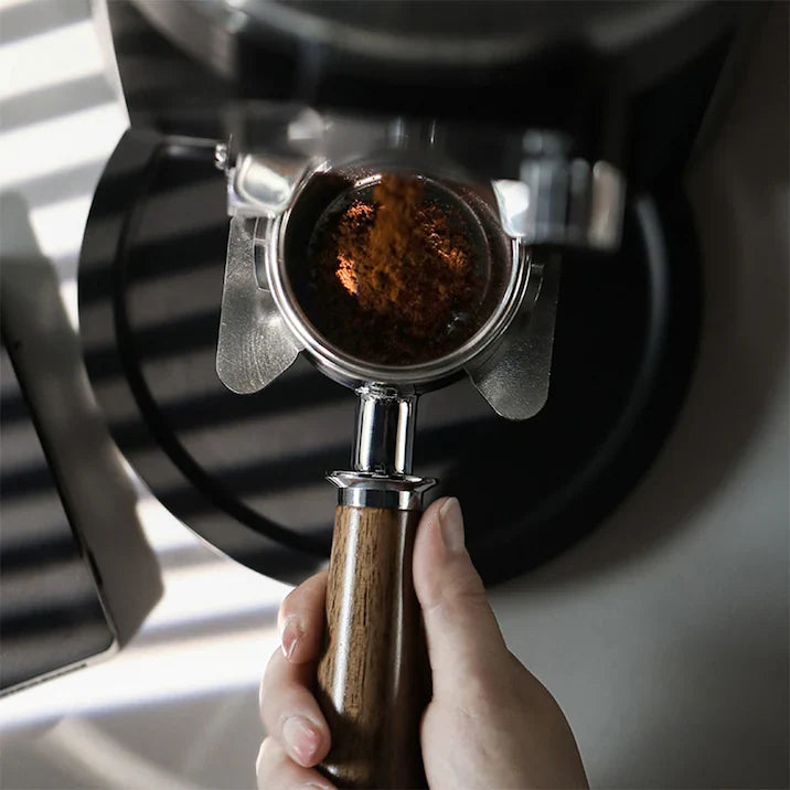 Comparatif machines et moulins – Porte-filtre sans fond avec café fraîchement moulu sous le moulin – Coffee Coaching Club