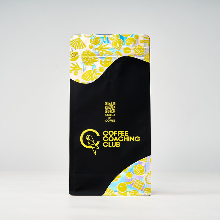 Blend di caffè Nutty Delight – retro del sacchetto da 250 g con codice QR «United by Coffee», design nero e giallo – Coffee Coaching Club