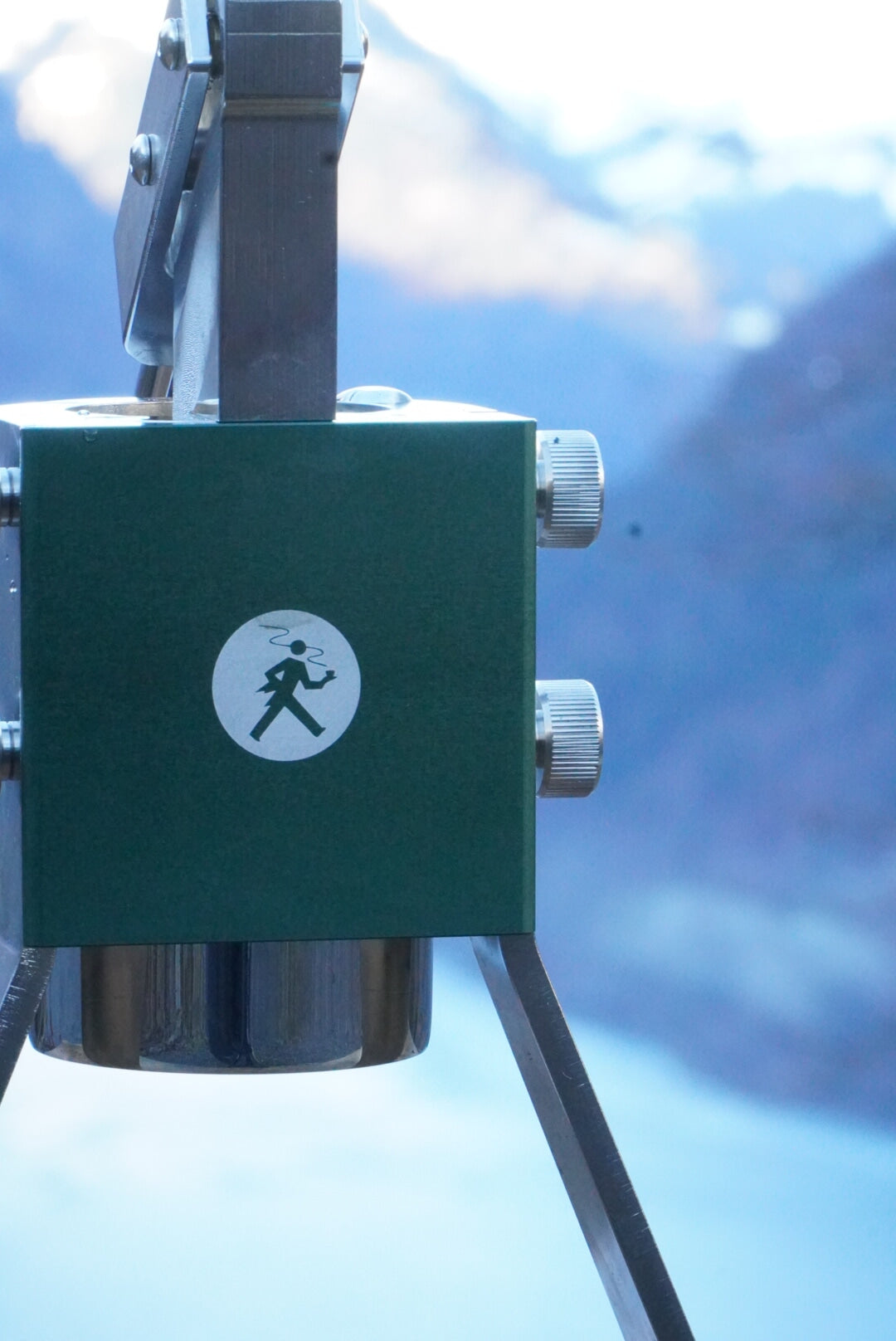 Olympia Express Mina Grün Brühkammer mit Logo vor Bergsee – Coffee Coaching Club 58