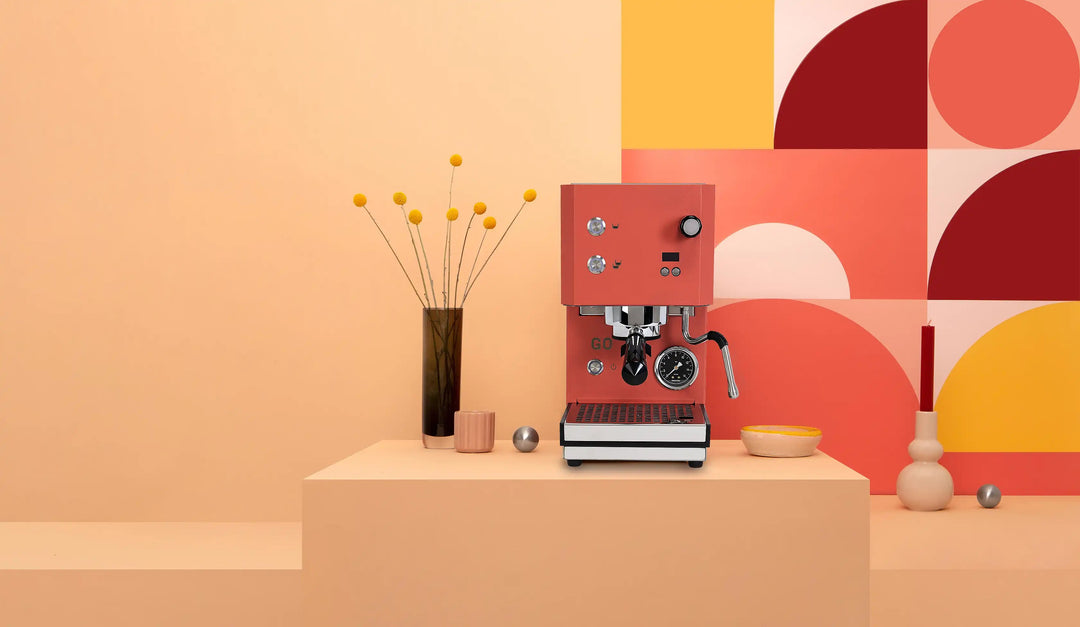 Profitec GO 2.0 Rot auf einem Podest vor apricotfarbenem Hintergrund – Coffee Coaching Club 8