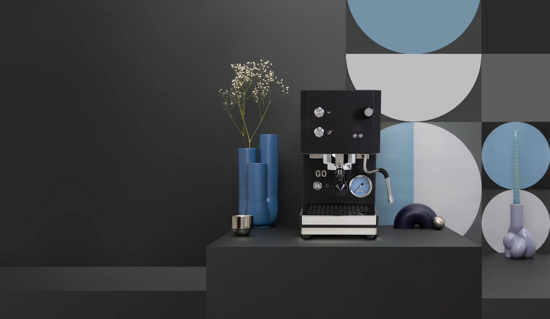 Profitec GO 2.0 Schwarz auf einem Podest mit Vasen und Tassen – Coffee Coaching Club 6