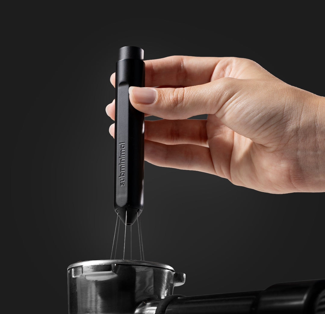 Subminimal Flick WDT Tool in der Hand über dem Siebträger – Coffee Coaching Club 12