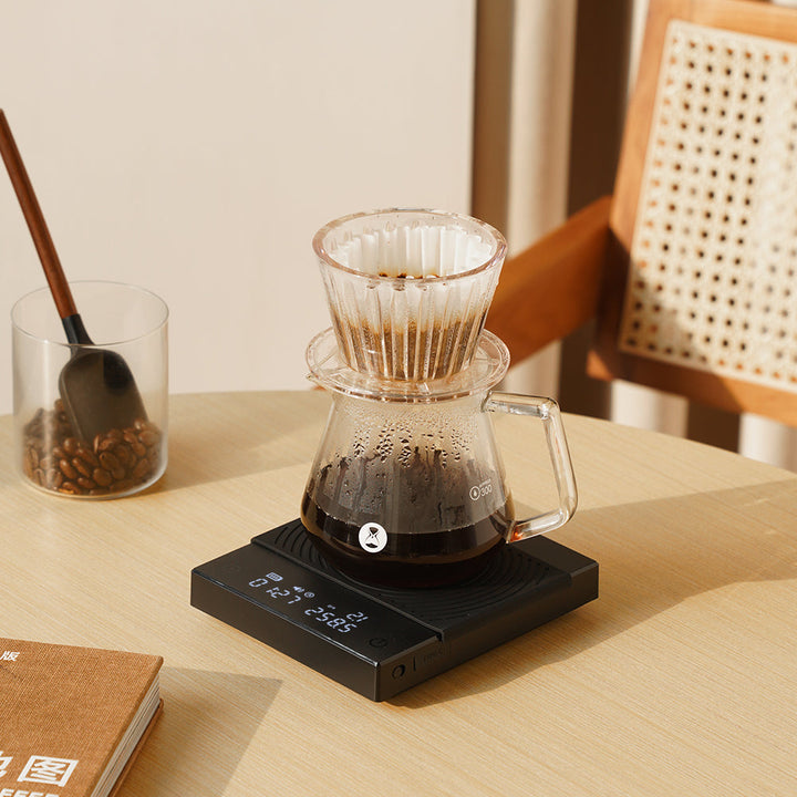 Timemore Black Mirror Basic 2 Schwarz mit Glas-Dripper und Kanne auf dem Tisch – Coffee Coaching Club 22